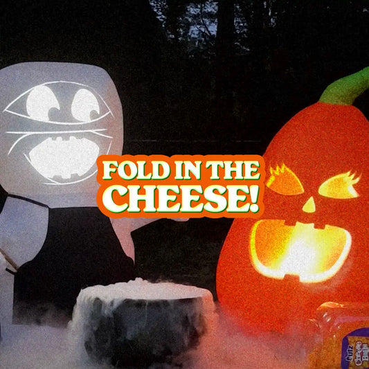 Lester the inflatable talking mummy talking to Spooky Spice the inflatable talking pumpkin over a bubbling cauldron and a bucket of their favorite snack, Cheese Balls